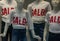 group of mannequins wearing a white t-shirt with written sales showcases to warn customers about discounts.