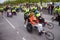 Group of marathon runners pushing running wheel chairs with disabled persons helping them fulfill the run.