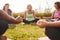 Group Of Mature Men And Women In Class At Outdoor Yoga Retreat Sitting Circle Meditating