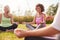 Group Of Mature Men And Women In Class At Outdoor Yoga Retreat Sitting Circle Meditating