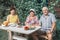 A group of mature people dine with natural products at a table in the garden