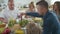 Group of mature people eating and passing dishes at the table. family gathered for celebration.