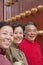 Group of mature people in traditional clothes standing next to traditional Chinese door, portrait