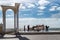 A group of men drag a heavy wagon along the seafront