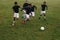 Group of men playing football on the field running for the ball. Soccer players running on field for possession of the ball