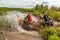 A group of men on quad bikes overcomes water obstacles. Cross-country tours