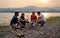 Group of men and woman friends with multi-ethnic enjoy to party and stay surrounded by fire and they look happy to join together