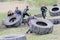 Group of men and woman struggling to tip a large tractor tire