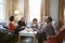 Group Of Middle Aged Friends Meeting Around Table In Coffee Shop