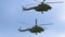 A group of military helicopters flying very close. Russian and US Army.