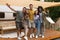 Group of millennial diverse friends posing and smiling at camera near RV, enjoying fun weekend together on camping trip