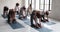 Group of millennial people performing Camel pose during yoga class