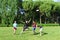 Group of mixed young teenagers people in casual wear playing with plastic flying disc game in a park oudoors. jumping woman catch