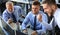 Group of modern business men in formalwear smiling and gesturing while working in the office