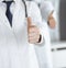 Group of modern doctors standing as a team with thumbs up or Ok sign in hospital office, close-up. Medical help