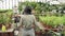 Group of modern gardeners working in a greenhouse. Agriculture, farming and gardening.