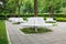 Group of modern iron circle shaped benches installed around tree for resting in city park