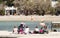 Group of mothers with baby strollers sitting on the beach in spring off-season