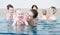 Group of mothers with children at baby swimming lesson