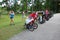 Group of mothers running with strollers in park.