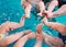 A group of mothers with their young children in a children`s swimming class with a coach.