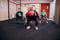 Group of motivated ladies squatting with extre weight