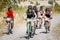 Group of mountain bike cyclists riding sandy track at sunny summer day, healthy lifestyle active athlete doing sport.