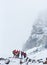 Group of mountaineers standing on snowy hillside.