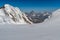 Group of mountaneers walking on a glacier in a sunny day: in bac