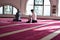 Group of muliethnic religious muslim young people  praying an dreading Koran together. Group of muslims praying in the mosque