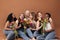 Group of multi-ethnic women sitting together in studio. Six smiling females with bouquets of flowers