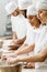 group of multiethnic bakers kneading