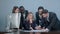 Group of multiethnic diverse young business people in a meeting standing around a table with serious expressions