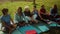 Group of multiracial senior friends taking a break sitting on mat after workout activity