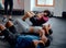 Group of multiracial young adults with trainer doing sit-ups at the gym