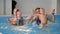 Group of mums with their baby children at infant swimming class