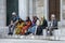 A group of Muslim women and two men sit on a step.