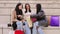 Group of mutiethnic happy young women suprised looking inside of a shopping bag outdoors. Three shopaholic girls