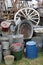 Group of old antique galvanied iron buckets and tin baths on display with various other vintage items including cart wheels