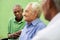 Group of old black and caucasian men talking in park