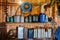 A group of old canisters and cylinders stand on shelves in a wooden shed