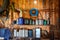 A group of old canisters and cylinders stand on shelves in a wooden shed