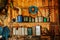 A group of old canisters and cylinders stand on shelves in a wooden shed