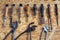 Group of old cobblers tools for handmade shoes production, awls and tongs for leather on wooden chipboard background, flat lay