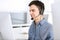 Group of operators at work. Call center. Focus on young man receptionist in headset at customer service. Business