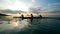 Group of paddlers are rowing across sunset waters