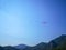 A group of parachuters flying high above a green hill in the summertime blue sky, Fethiye, Mugla