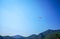 A group of parachuters flying high above a green hill in the summertime blue sky, Fethiye, Mugla