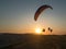 Group of paragliders flying at sunset