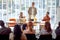 A group of participants is congratulating to a young businessman on an interesting business lecture in the conference room.